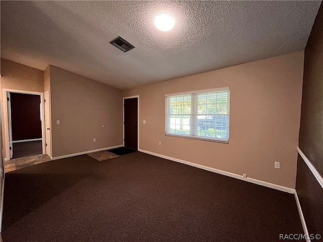 carpeted spare room featuring a textured ceiling