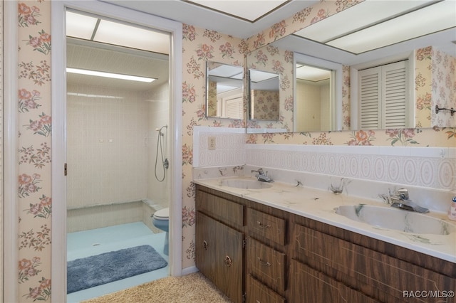 bathroom featuring tiled shower, vanity, and toilet