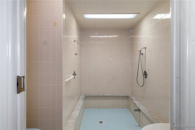 bathroom with tiled shower and toilet