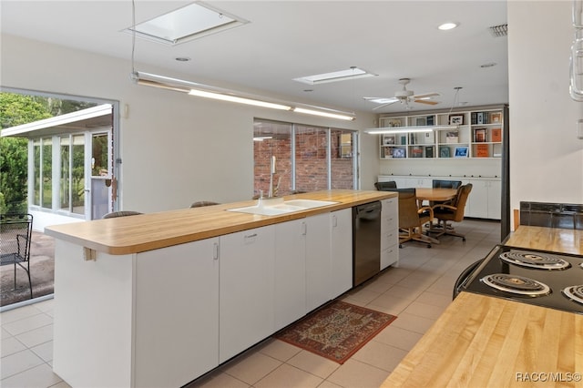 kitchen with ceiling fan, sink, light tile patterned floors, dishwasher, and white cabinets