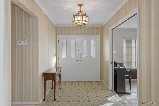 foyer entrance featuring ornamental molding and an inviting chandelier