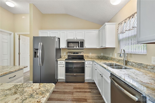 kitchen with white cabinetry, sink, a textured ceiling, vaulted ceiling, and appliances with stainless steel finishes