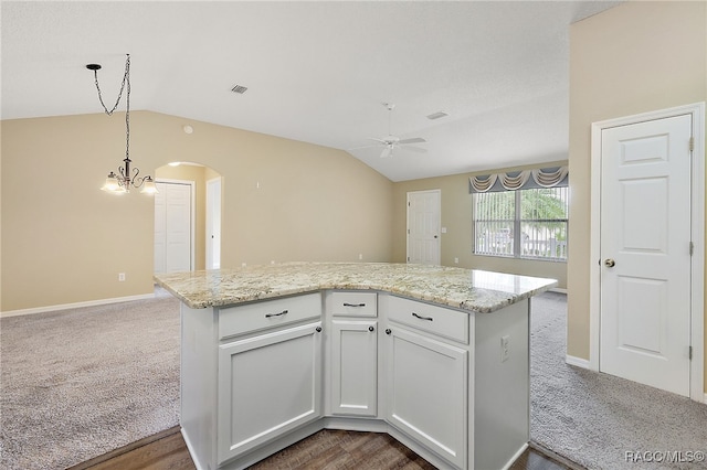 kitchen with pendant lighting, lofted ceiling, white cabinets, ceiling fan with notable chandelier, and dark hardwood / wood-style flooring