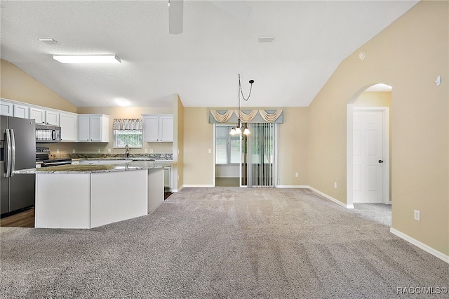 kitchen featuring white cabinetry, lofted ceiling, a healthy amount of sunlight, and appliances with stainless steel finishes