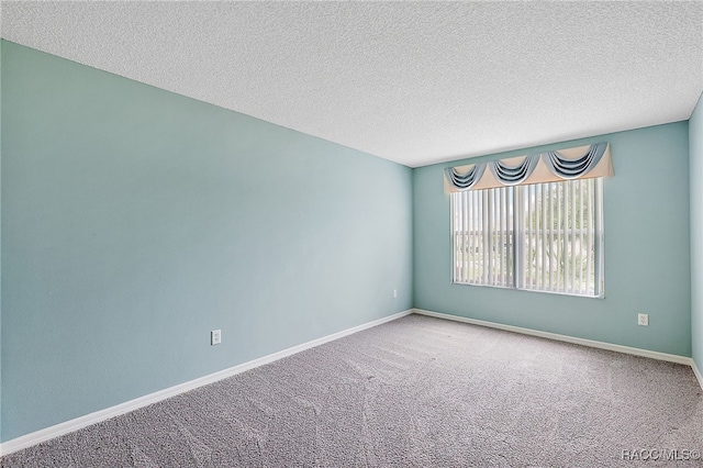 carpeted spare room featuring a textured ceiling