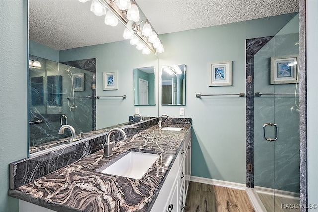 bathroom with vanity, hardwood / wood-style floors, a textured ceiling, and an enclosed shower