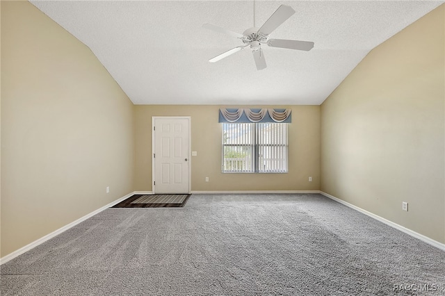 carpeted empty room featuring a textured ceiling, ceiling fan, and vaulted ceiling