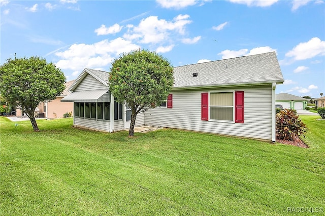 back of property featuring a sunroom and a yard