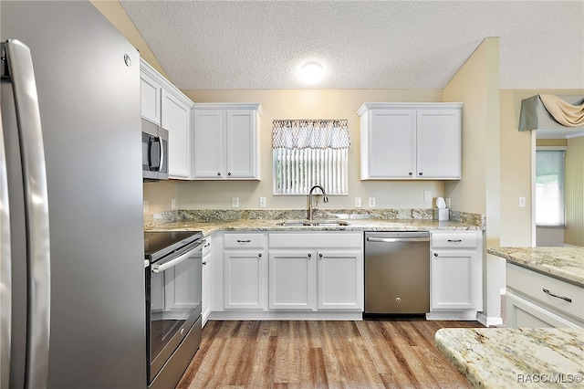 kitchen featuring a wealth of natural light, white cabinetry, sink, and appliances with stainless steel finishes