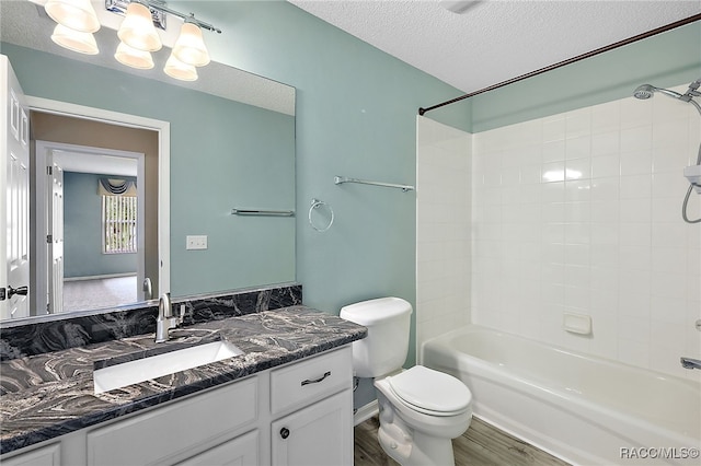 full bathroom featuring bathing tub / shower combination, a textured ceiling, toilet, vanity, and hardwood / wood-style flooring