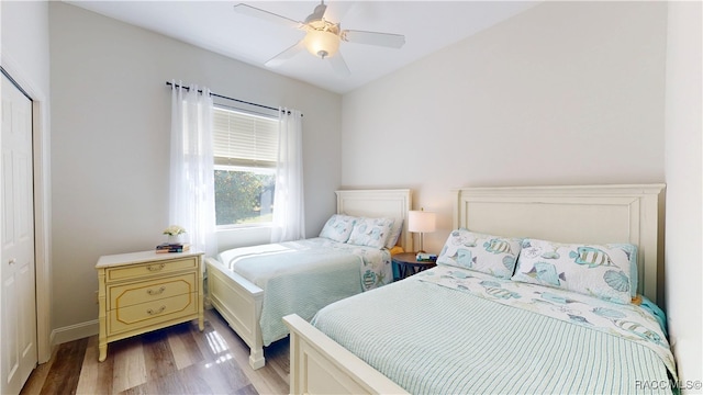 bedroom featuring a closet, light wood-style flooring, and a ceiling fan