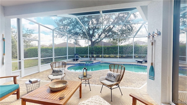 view of swimming pool featuring a patio, a lanai, and a pool with connected hot tub