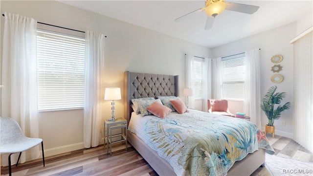 bedroom with a ceiling fan, baseboards, and wood finished floors