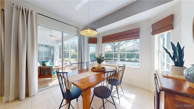 dining space featuring light tile patterned floors and baseboards