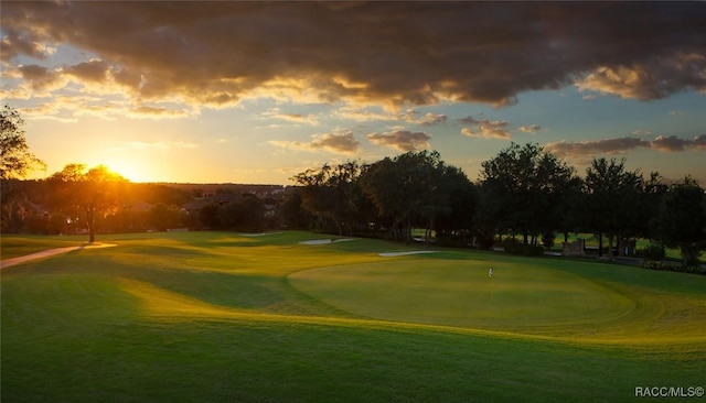 surrounding community with view of golf course and a yard