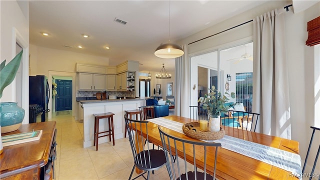 dining space with light tile patterned floors, recessed lighting, visible vents, and ceiling fan with notable chandelier