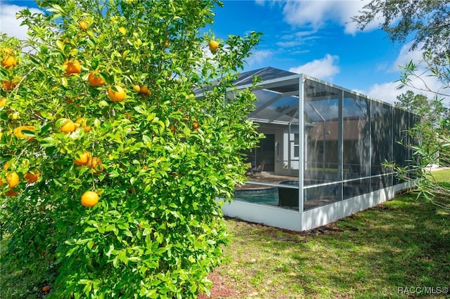 view of side of home with a lanai and a yard