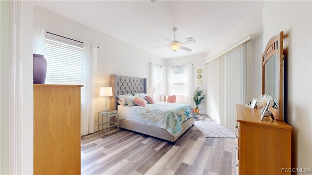 bedroom featuring visible vents, wood finished floors, and a ceiling fan