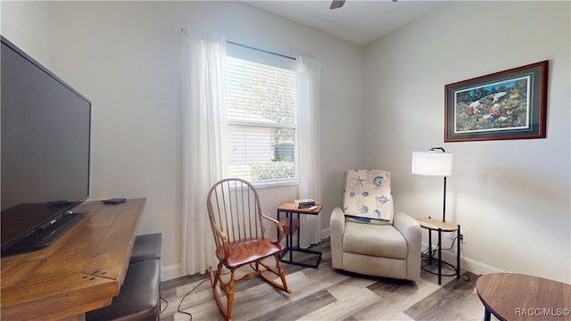 sitting room with ceiling fan, wood finished floors, and baseboards