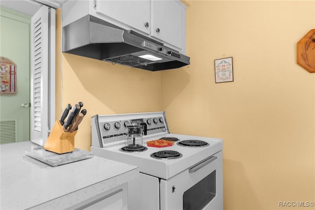 kitchen featuring electric stove and white cabinets