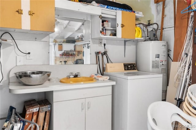 clothes washing area featuring water heater, washer / clothes dryer, cabinets, and sink