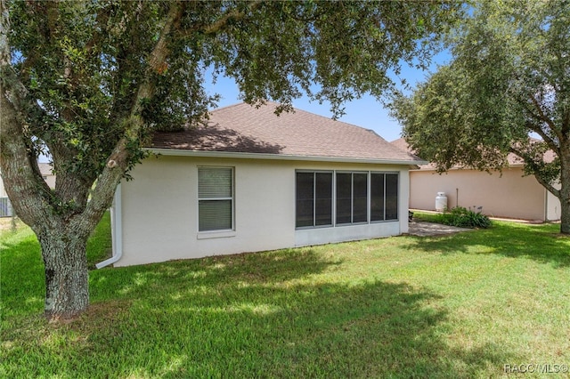 4614 N Webster Island Ter, Hernando, FL 34442 - rear view of house with stucco siding, a yard, and roof with shingles
