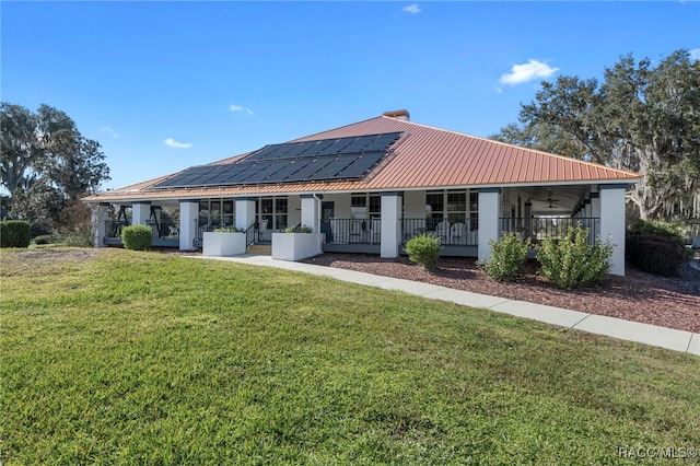4614 N Webster Island Ter, Hernando, FL 34442 - view of front of home with solar panels, a front lawn, covered porch, a metal roof, and a chimney