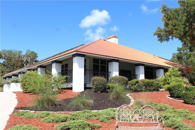 4614 N Webster Island Ter, Hernando, FL 34442 - view of home's exterior with stucco siding, a chimney, and a metal roof