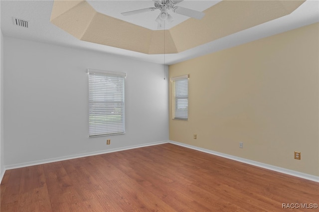 4614 N Webster Island Ter, Hernando, FL 34442 - empty room featuring wood finished floors, ceiling fan, and a tray ceiling