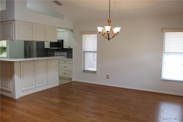 4614 N Webster Island Ter, Hernando, FL 34442 - kitchen featuring stainless steel microwave, a chandelier, vaulted ceiling, tasteful backsplash, and light wood finished floors