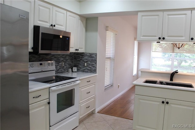 4614 N Webster Island Ter, Hernando, FL 34442 - kitchen with appliances with stainless steel finishes, tasteful backsplash, white cabinets, and light tile patterned floors