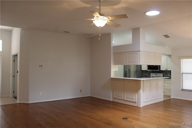 4614 N Webster Island Ter, Hernando, FL 34442 - kitchen with stainless steel appliances, a peninsula, light wood-type flooring, backsplash, and ceiling fan