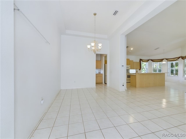 tiled empty room with a notable chandelier