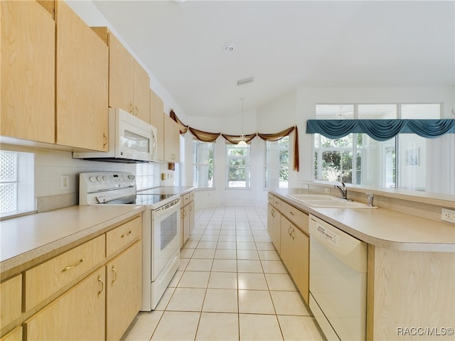 kitchen with light brown cabinets, white appliances, sink, and light tile patterned floors