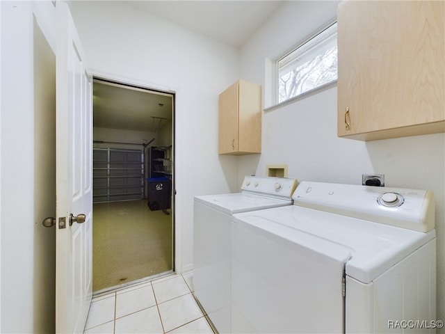 clothes washing area featuring separate washer and dryer, light carpet, and cabinets