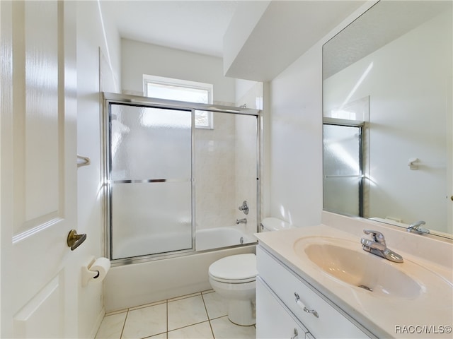 full bathroom featuring tile patterned flooring, vanity, enclosed tub / shower combo, and toilet