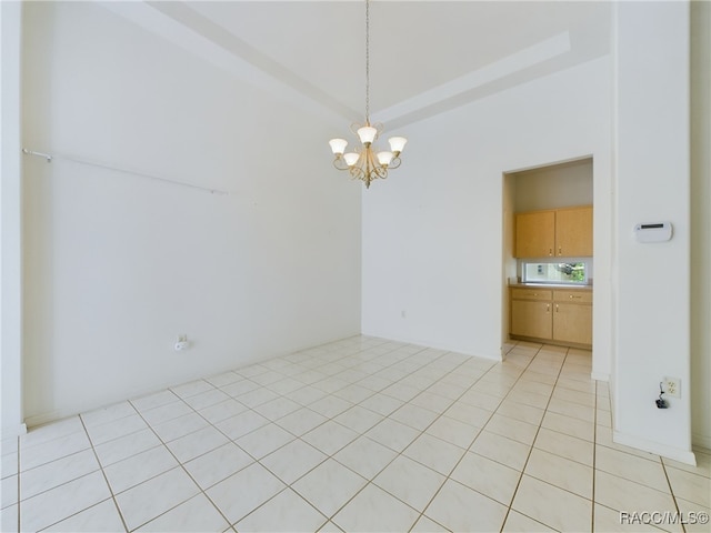 tiled empty room with a notable chandelier