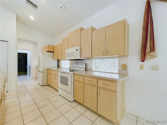 kitchen featuring lofted ceiling, light brown cabinets, white appliances, and light tile patterned floors