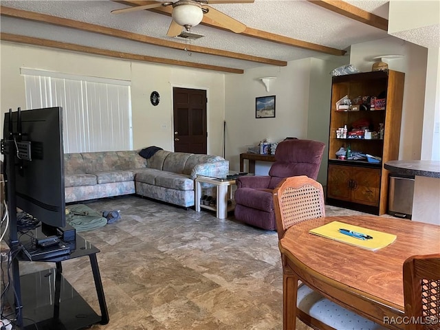 living area with ceiling fan, a textured ceiling, and beamed ceiling