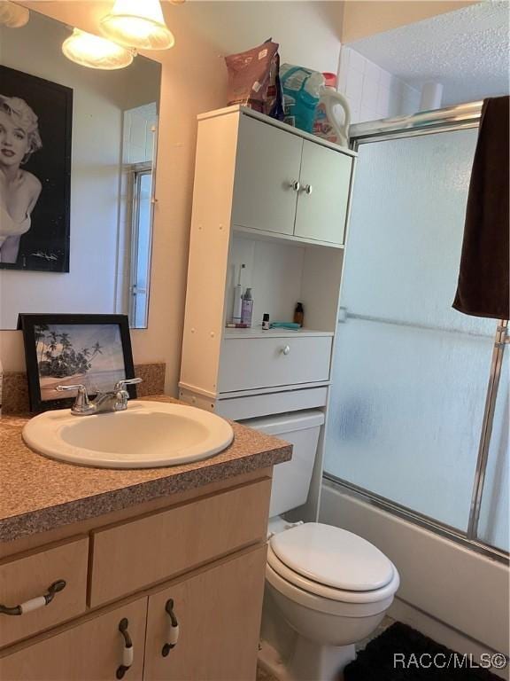 full bathroom with toilet, shower / bath combination with glass door, and vanity