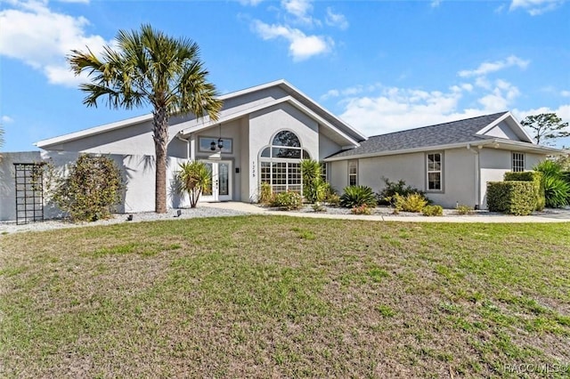 mid-century inspired home with stucco siding, a front lawn, and french doors