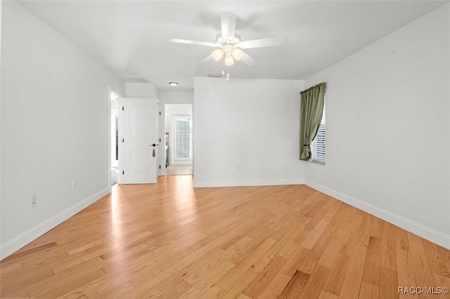 empty room with light wood-style floors, baseboards, and a ceiling fan