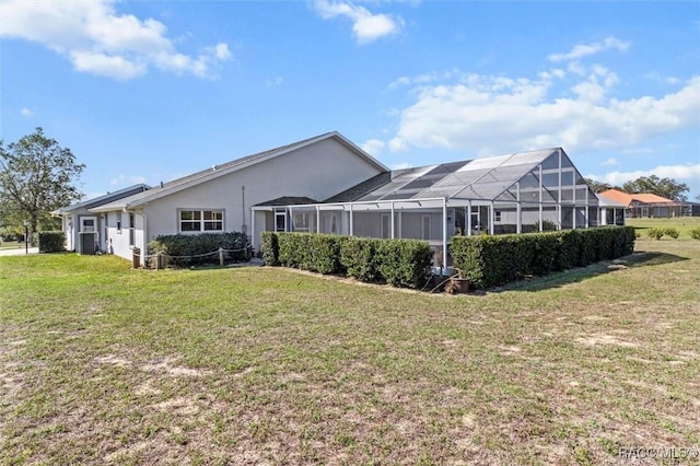 rear view of property featuring glass enclosure, a lawn, central AC unit, and stucco siding