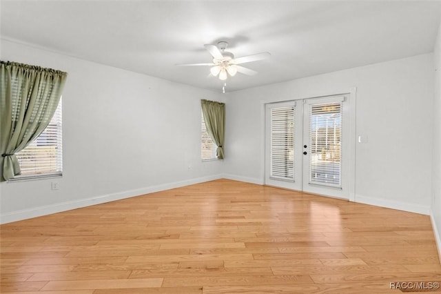 empty room with french doors, light wood-type flooring, and baseboards