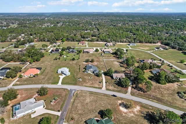 bird's eye view with a wooded view