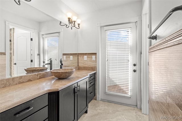 bathroom featuring a notable chandelier, vanity, and a healthy amount of sunlight