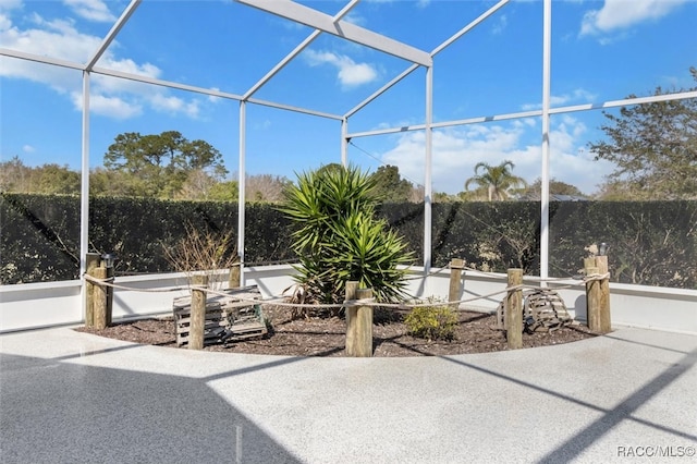 view of patio with a lanai and fence