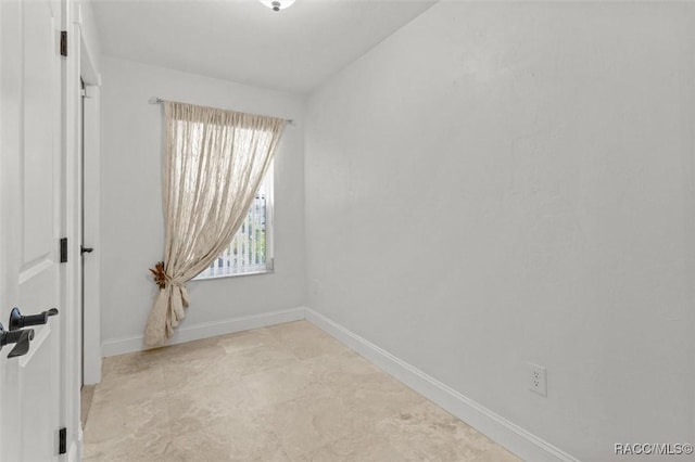 spare room with baseboards