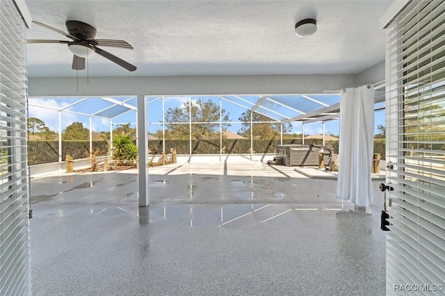 view of patio featuring a pool, glass enclosure, a ceiling fan, and a hot tub