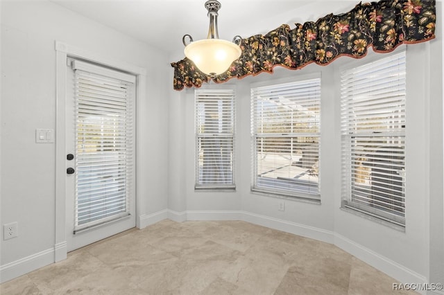 unfurnished dining area featuring baseboards